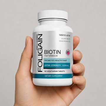 一隻手拿著一瓶FOLIGAIN生物素速溶錠。
